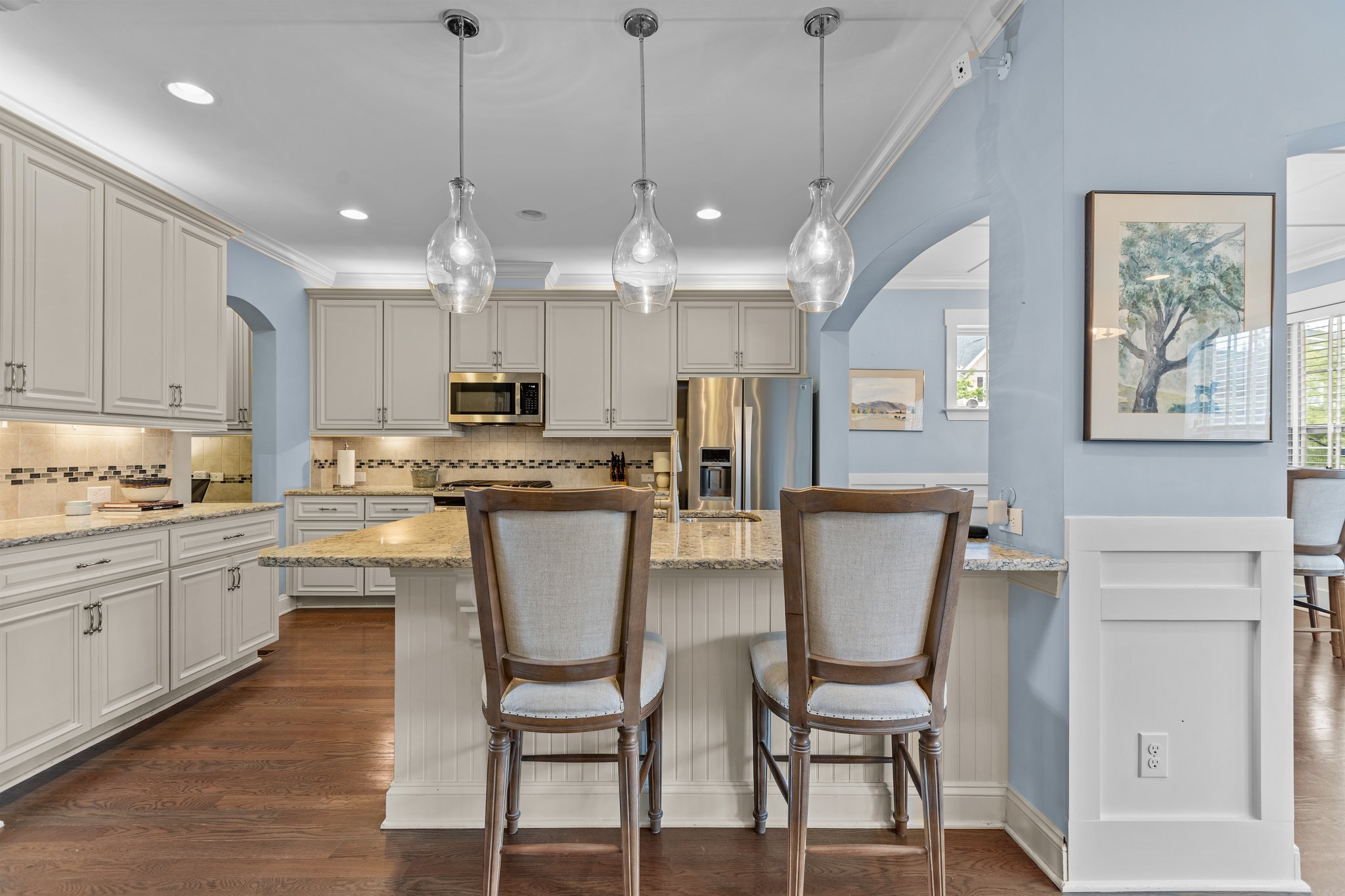 kitchen with pastel colors with natural lighting and complementing stone countertops