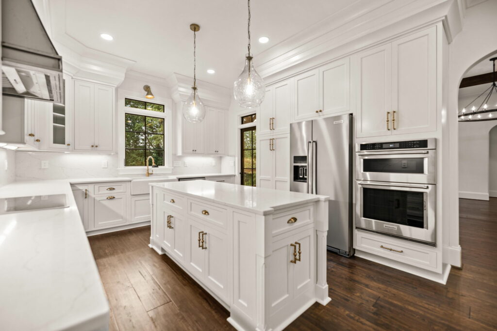 A sun-drenched kitchen featuring beautiful countertops, stainless steel appliances, and lush greenery outside the window for a real estate video.